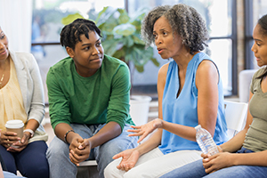 Photo of a counselor working with a group of young adults 